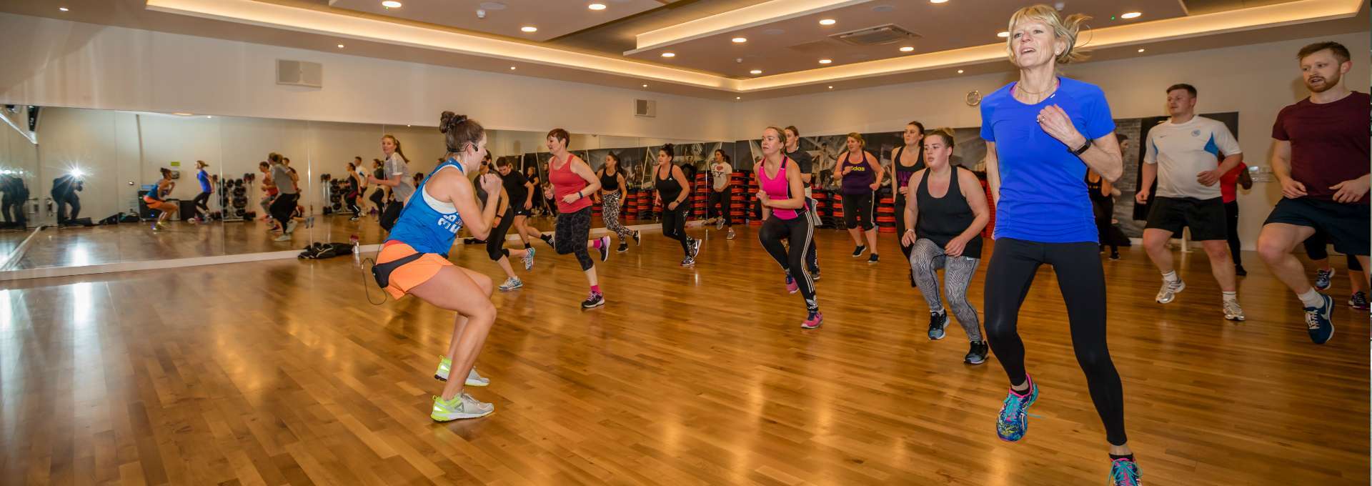 Clase grupal de aerobics dirigida por una instructora